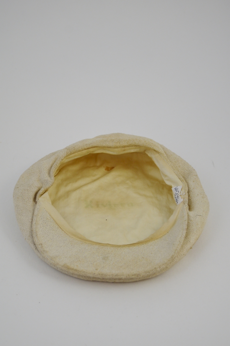 Oval form, "alpeluefasong" m/innfelt stykke midt foran hvor også bremmen sitter, avstivet. En rusten trykknapp på bremmen regulerer fasongen på luen. Foret.