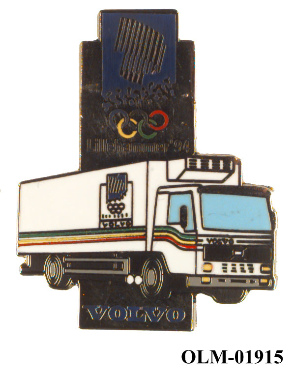 Smal rektangulært stående merke med emblemet for Lillehammer '94 øverst og logo for Volvo nederst. En hvit varebil går utenover bredden på merket i bakgrunnen.