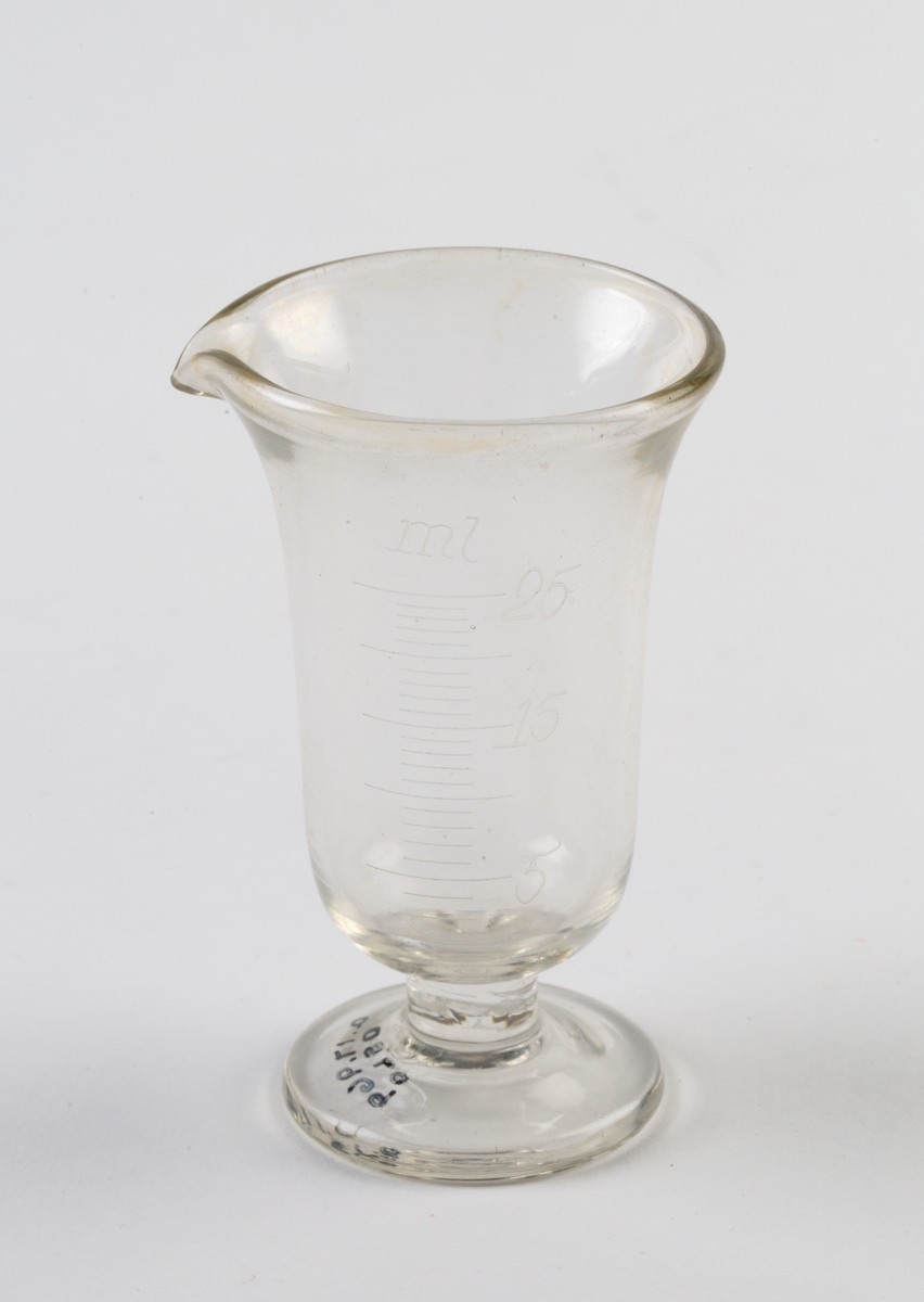 Gradert måleglass med stett og helletut.