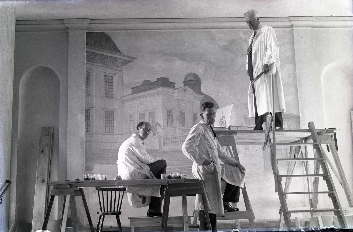 Prins Eugen assisterad av två medhjälpare utför dekorationsmålning i Kalmar läroverk.