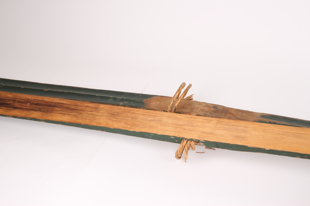 Et par treski i helved med lang og smal tupp, flat overside og fortykning under. Avsmalnende framski og jevnbred bakski og møneformet rygg langs hele skiens lengde. Dekoren er fra Krødsherad med fremre del av framskien malt i svart, og med rosett og navn med årstall i hvitt. Rosett også på skienes bakende. Skiene har tåstropp av vidje og har sannsynligvis hatt ilkebinding. Bindingshullene har innskjæring med skråsnitt på skienes sider. Skiene er rett avskåret bak. Ingen rand under.