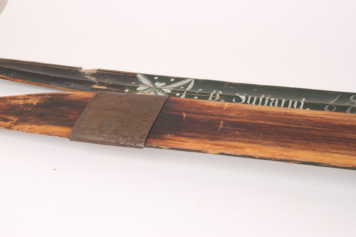 Et par treski i helved med lang og smal tupp, flat overside og fortykning under. Avsmalnende framski og jevnbred bakski og møneformet rygg langs hele skiens lengde. Dekoren er fra Krødsherad med fremre del av framskien malt i svart, og med rosett og navn med årstall i hvitt. Rosett også på skienes bakende. Skiene har tåstropp av vidje og har sannsynligvis hatt ilkebinding. Bindingshullene har innskjæring med skråsnitt på skienes sider. Skiene er rett avskåret bak. Ingen rand under.