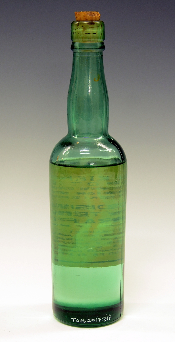 Medisinflaske i grønnfarget glass med korkpropp og innhold: Medisinsk flytende parafin fra Skiens Apotek.