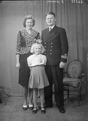 Gruppebilde. Familie. Gruppe på 3. Mor, far og ung pike. Bes