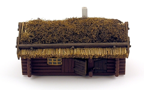 Modell av en knuttimmrad stuga med vass och mosstak. Från Dagsnäs, Skara