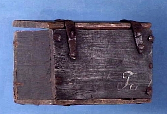 Låda m. lock, tillverkad av en gästgivaretavla, inköpt till museet för 2:-, låsanordning saknas, något sprucket, på insidan syns märken efter ris el. andra gryn