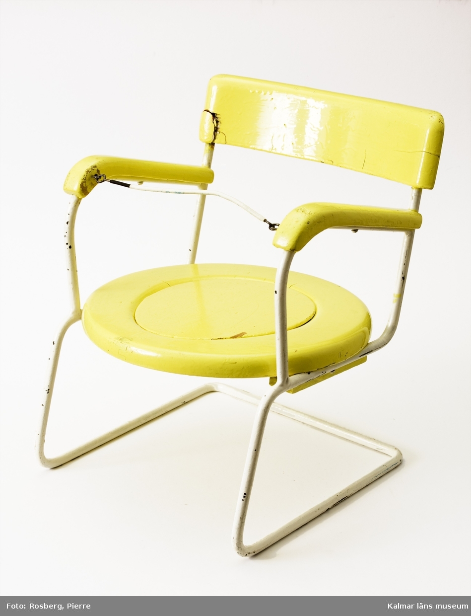 KLM 44486:3. Pottstol, barnpottstol. Av trä och metall. Stomme av vitlackerad metall. Sits och rygg av trä och är målade i en stark gul färg, har ursprungligen varit svagt mattgul.