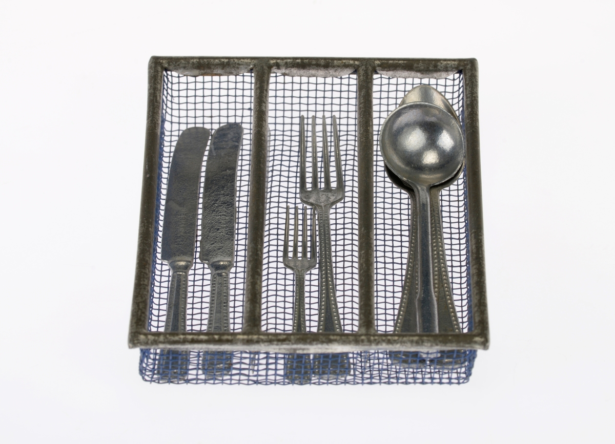 En liten bestikkurv med lekebestikk i. Alt er laget av metall. Gjenstandene er undernummerert 01-08, på de minste gjenstandene står kun undernummeret da det ikke var plass til hele FTT-nummeret.
FTT.54449.01: En trådkurv laget av blå metallnetting som er falset sammen med blankt metall. Bestikkurven har tre rom.
FTT.54449.02-03: To kniver med bredt blad og avrundet i enden. Skaftet har prikkmønster langs kanten og en opphøyet stripe i midten.
FTT.54449.04-05: To gafler med lik utforming men av ulik størrelse. Begge har fire tenner. På skaftet er det prikkmønster langs kanten og en opphøyet stripe på midten.
FTT.54449.006-07: To identiske skjeer. På skaftet er det prikkmønster langs kanten og en opphøyet stripe på midten.
FTT.54449.08: En liten øse med rundt hode. Skaftet er rundt før det blir flatt i enden. I endene er det også krokformet (for oppheng).