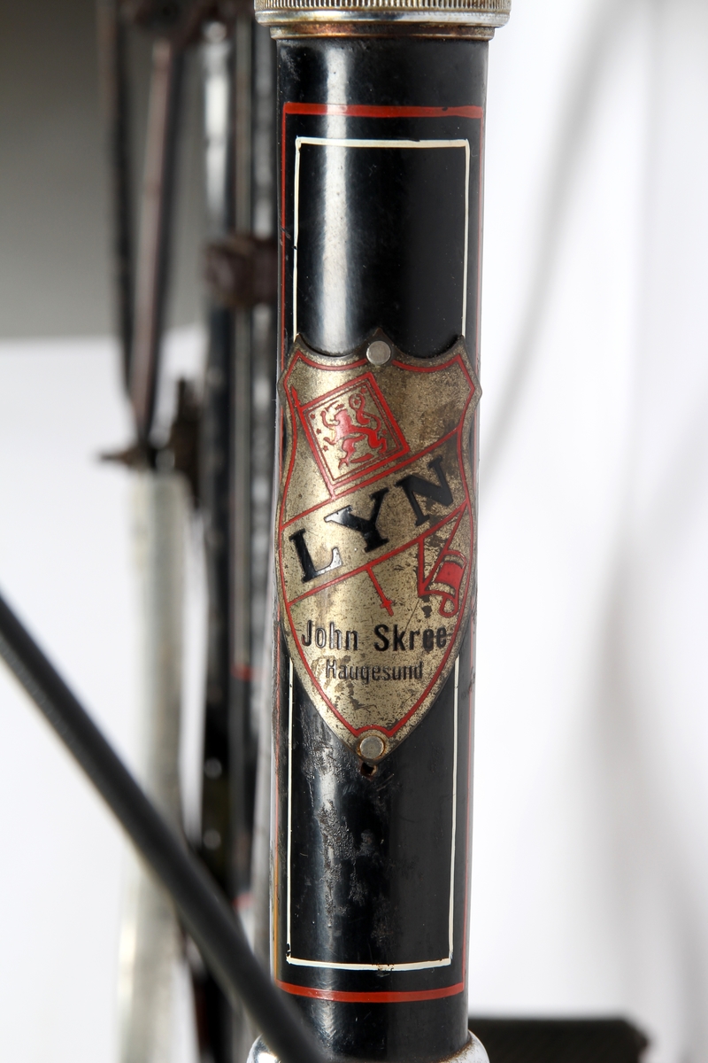 sort sykkel med røde og hvite markeringsstriper på sykkelrammen