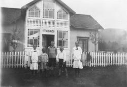 Personer, klær, bolighus, gjerde.