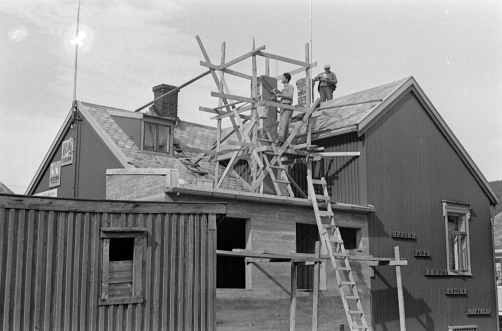 Murere/snekkere i arbeid med ny og gammel pipe på taket til Optikus Sigvald Johnsen ,i forbindelse med utbygging.
