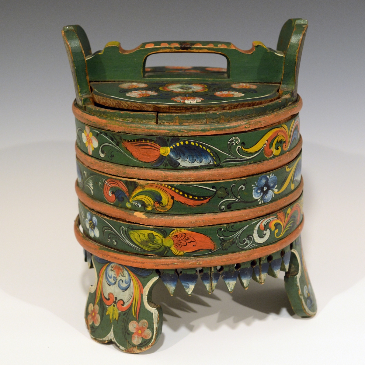 Fra protokollen:
Grøtbøtte, rosemalt av Kittel Østerholt, Lunde. Merket ATD 1868.

Grautspann med lokk. Grautspannet er lagget. Innvendig umalt, utvendig rosemalt. Det er 3 stk brede føtter og tagger i i mellom.