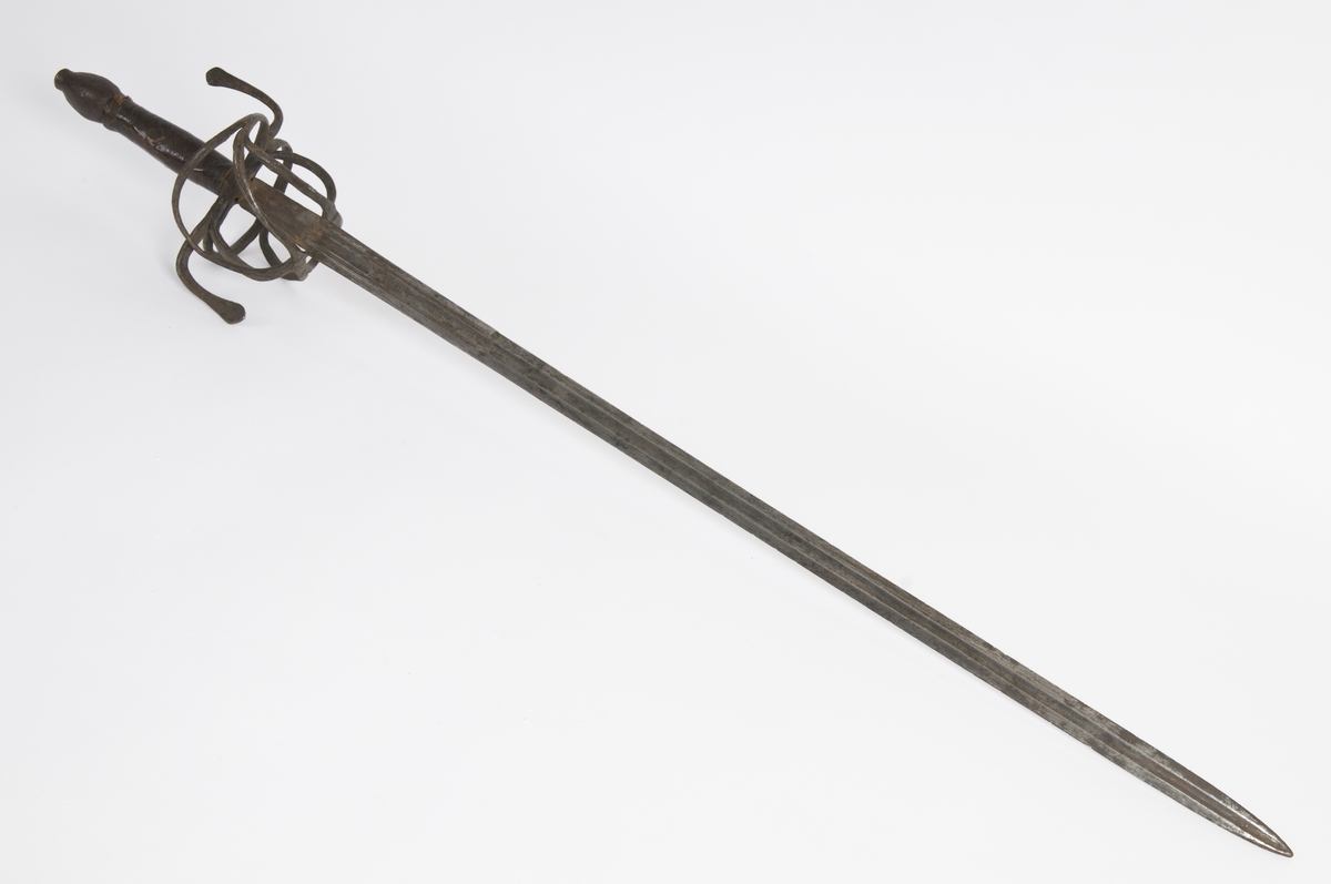 Plommeformet knapp. Tregrep  med lær bevokling.. Asymmetrisk feste med flate parerbøyler.  S formede parerstenger med utsmidde avslutninger..
Tveegget, rett klinge med rombeformet tverrsnitt og bred blodrand på begge siser 2 smale blodrender mot klingebrystet. Blodranden er merket WEILM KLEIN på begge sider. Klingen eravkortet.