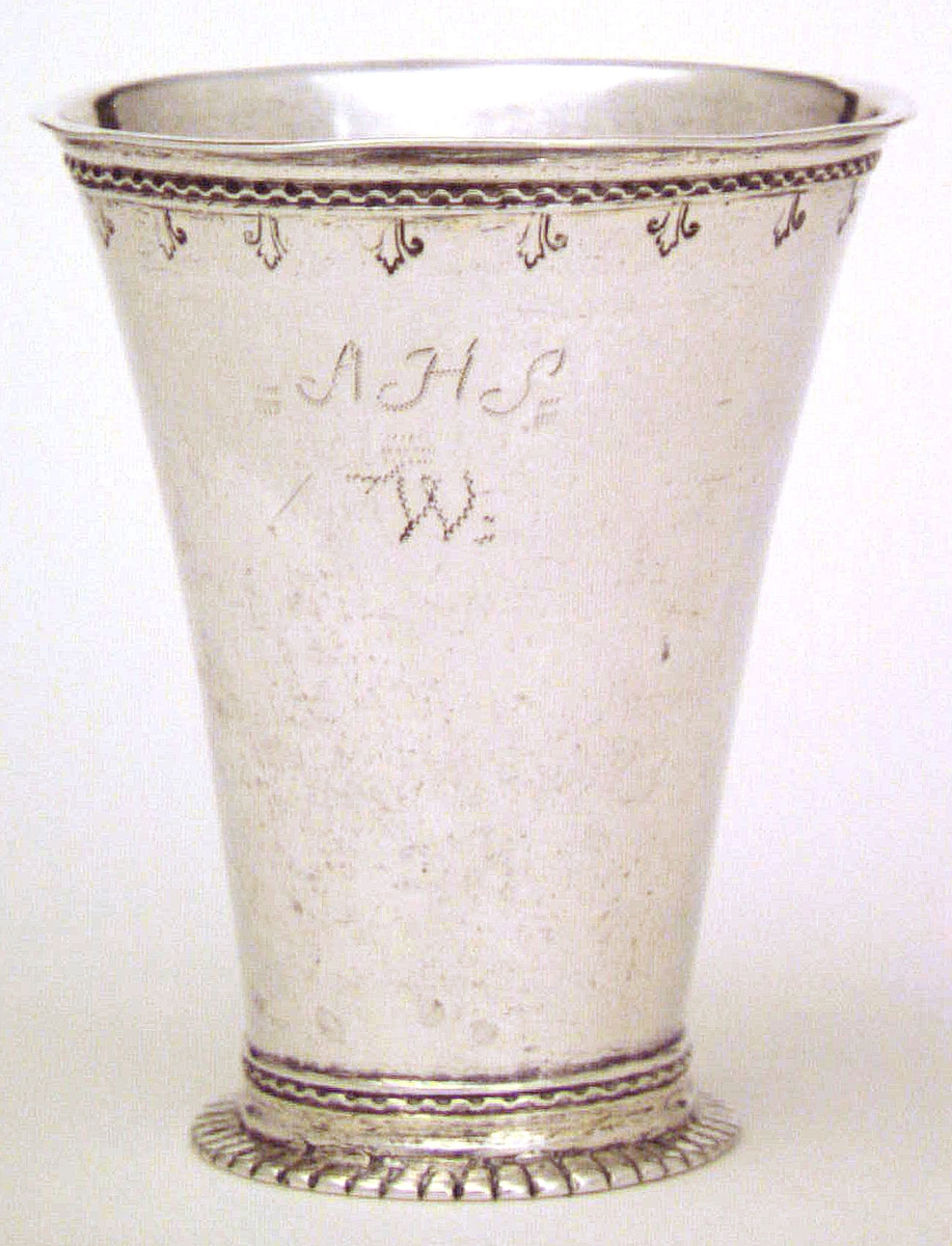 Bägare av silver. Flera ingraverade initialier; AHS W. Ej tydda stämplar i botten, bl a en åldermansranka. Inristat HAS. 1700-tal.