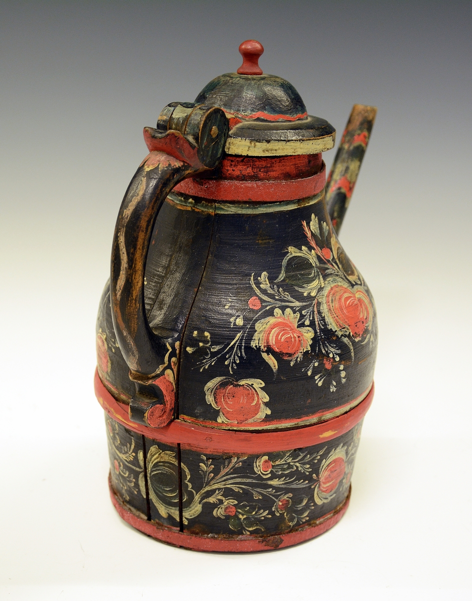 Tutekanne i tre. Fra protokollen: Ølkande med tut, laak og hank; dreiet arbeide i 2 halvdeler; rosemaling paa sort bund.