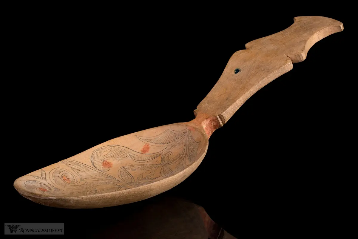 Stiliserte blad som er risset inn og fargesatt med mørk blå farge. Detaljer i rødt.