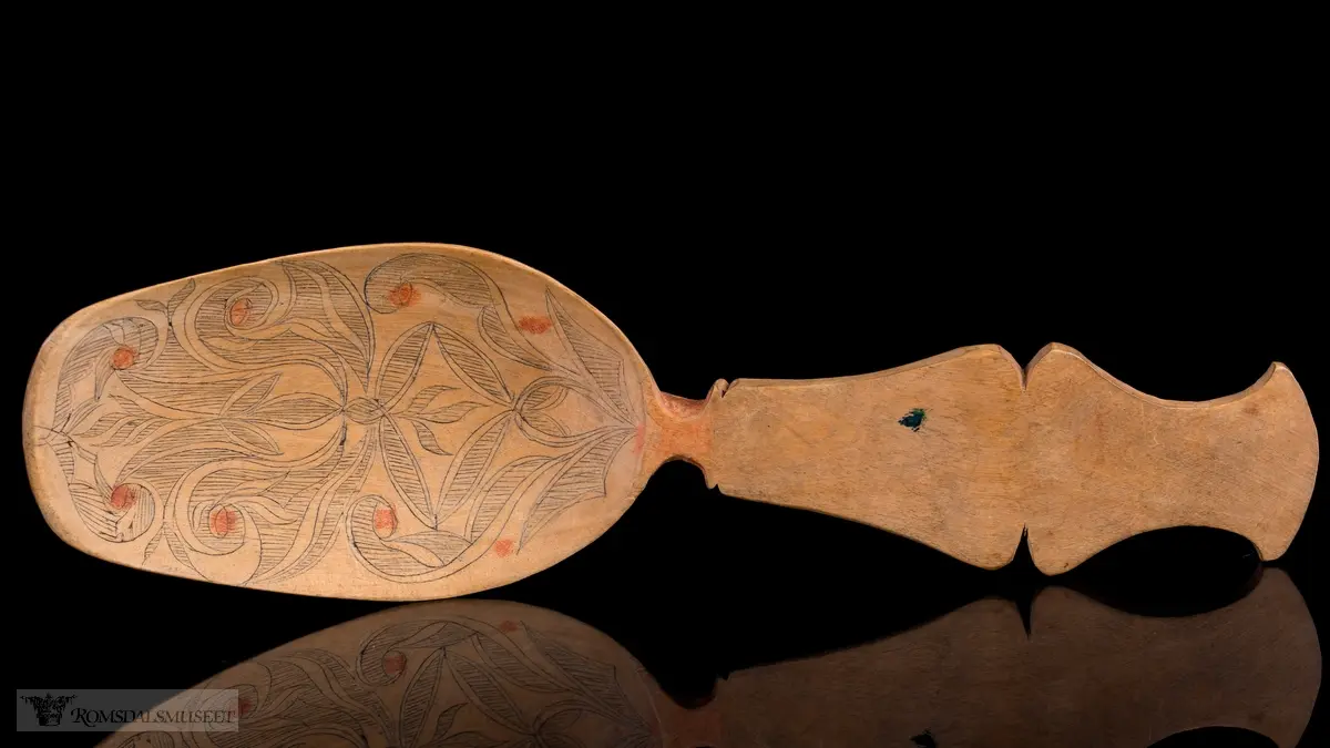 Stiliserte blad som er risset inn og fargesatt med mørk blå farge. Detaljer i rødt.