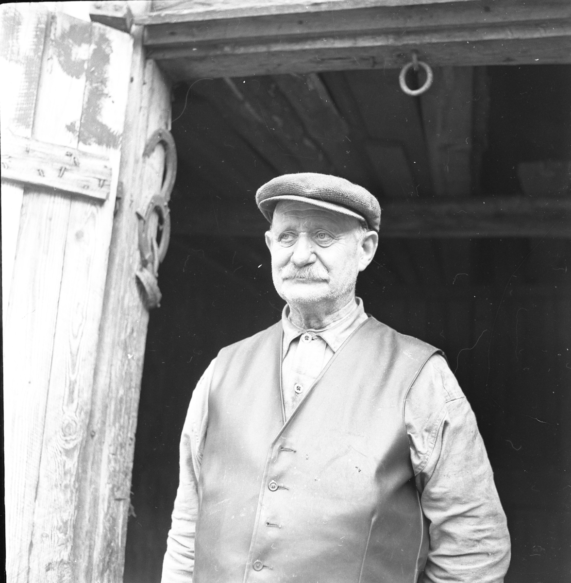 Porträttbild av smeden och hovslagaren Josef Johansson utanför sin smedja i Nordlunda, Lommaryd.