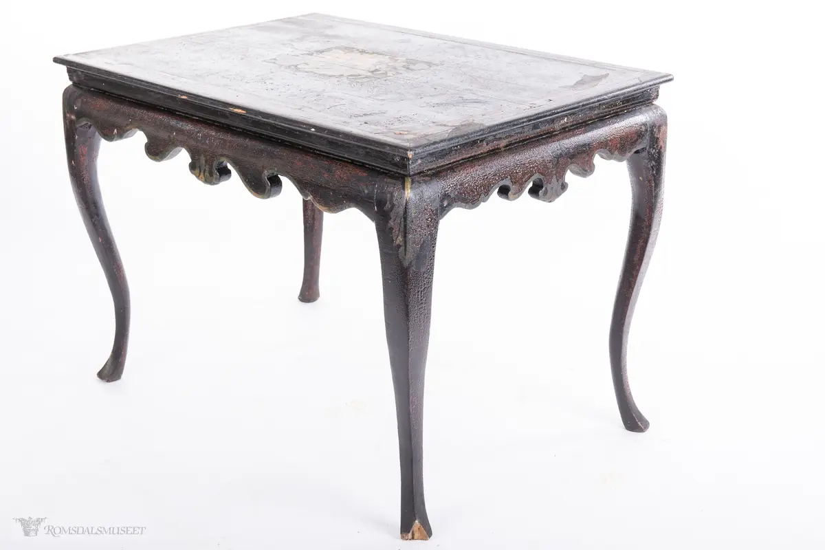 Et stilleben sentralt på bordplaten av en klase med plommer, to fersken, den ene brutt åpen, to nøtter og en fiken.