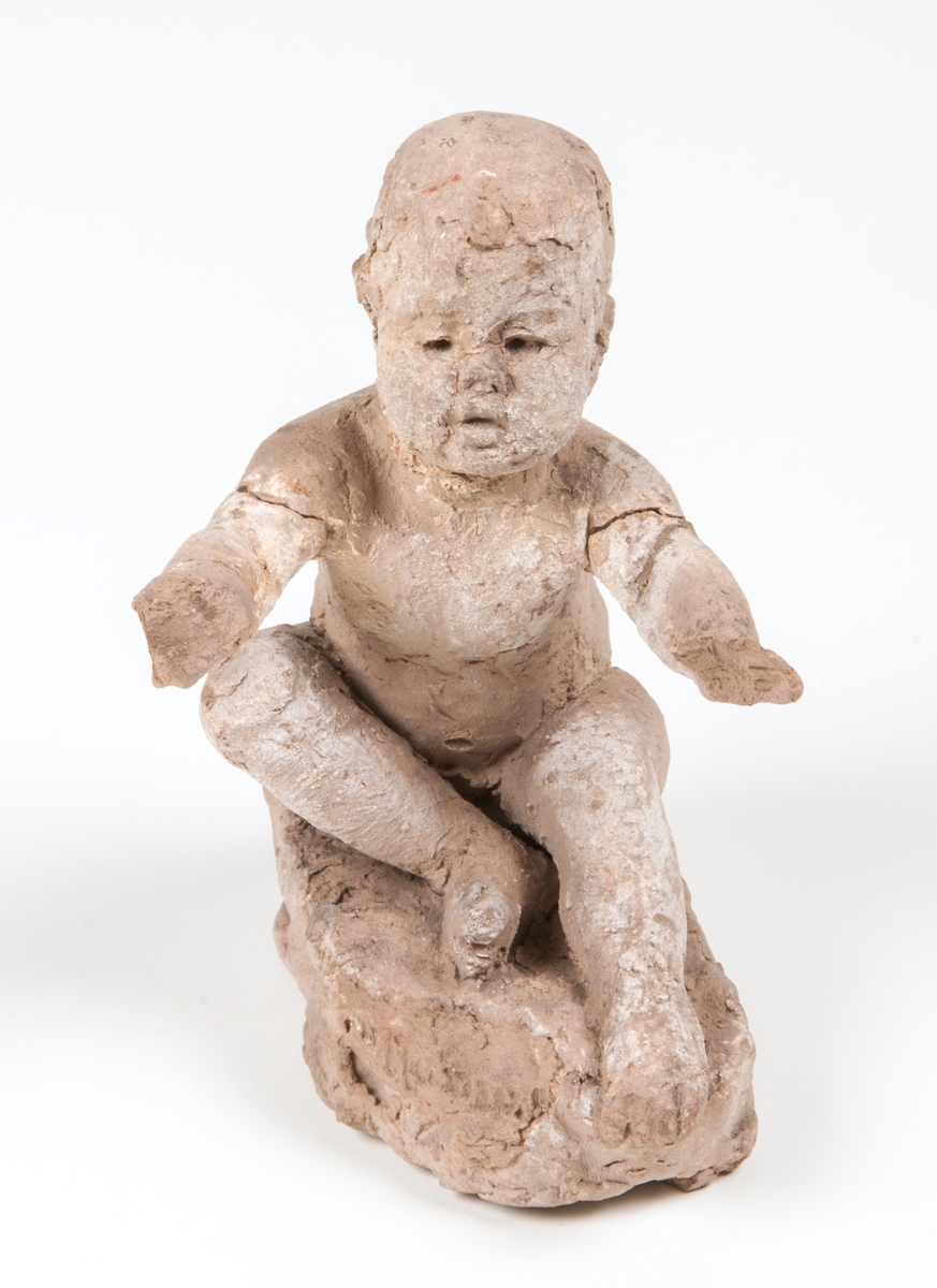 Skiss i terracotta till skulpturen Bebé. Sittande barn med utsträckta armar.