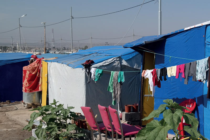Klær som henger til tørk ved siden av telt i en flyktningleir.