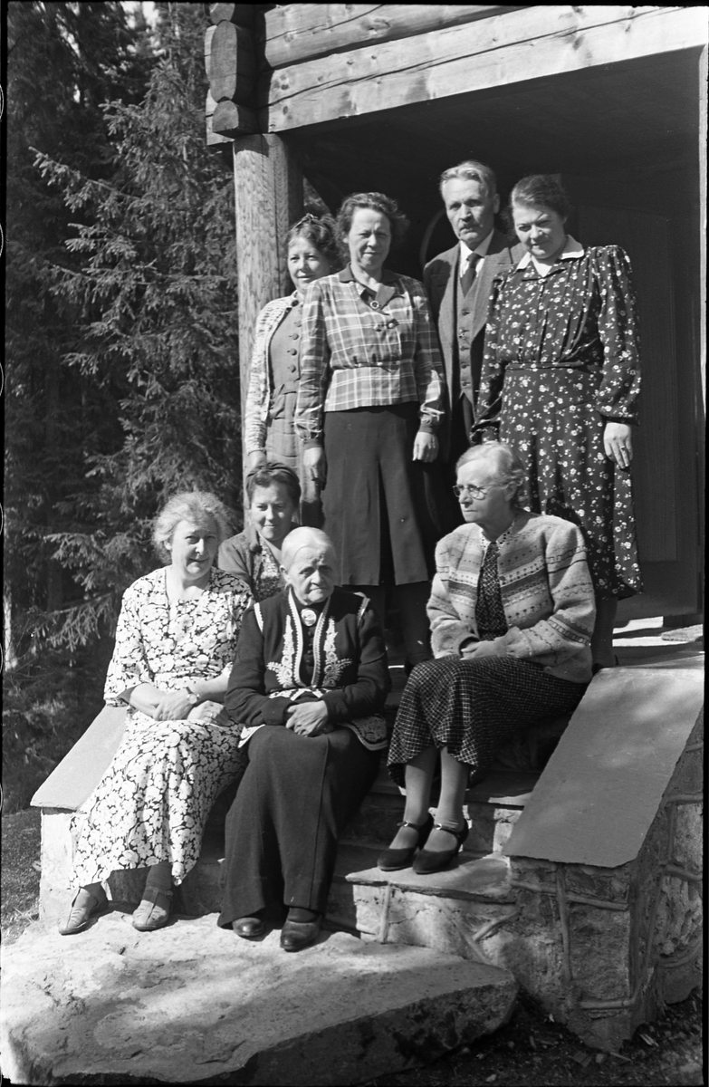 Sogneprest i Hoff, Ingebrigt Hole, og noen kvinner fotografert foran Holes hytte ved Skjeppsjøen på Totenåsen. Fire bilder.
Personene er (plasseringene referer til bilde nr. 1): Fremst til høyre prestens kone, Maria Hole, til venstre for henne Otilie Nøkleby. Bak Othilie sitter hennes datter Olaug (Rust). Kvinnene som står bakerst er Othilie Nøklebys døtre: Lengst til venstre Margit, dernest Borghild, og lengst til høyre Nora. Mellom dem står Ingebrigt Hole. Kvinnen som sitter til høyre i midten er ikke identifisert.