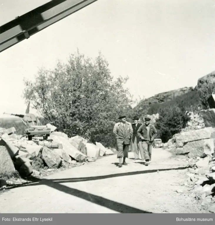 Tre män går längs en väg i ett stenbrott