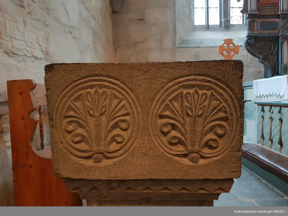 Et mønster bestående av to sidestilte palmetter inni hver sin sirkel , sees på hver side av den kvadratiske døpefontens øvre del. Enkelte steder sees også tegn på at det originalt har gått en mønster/dekorlinje langs nedre kanten.