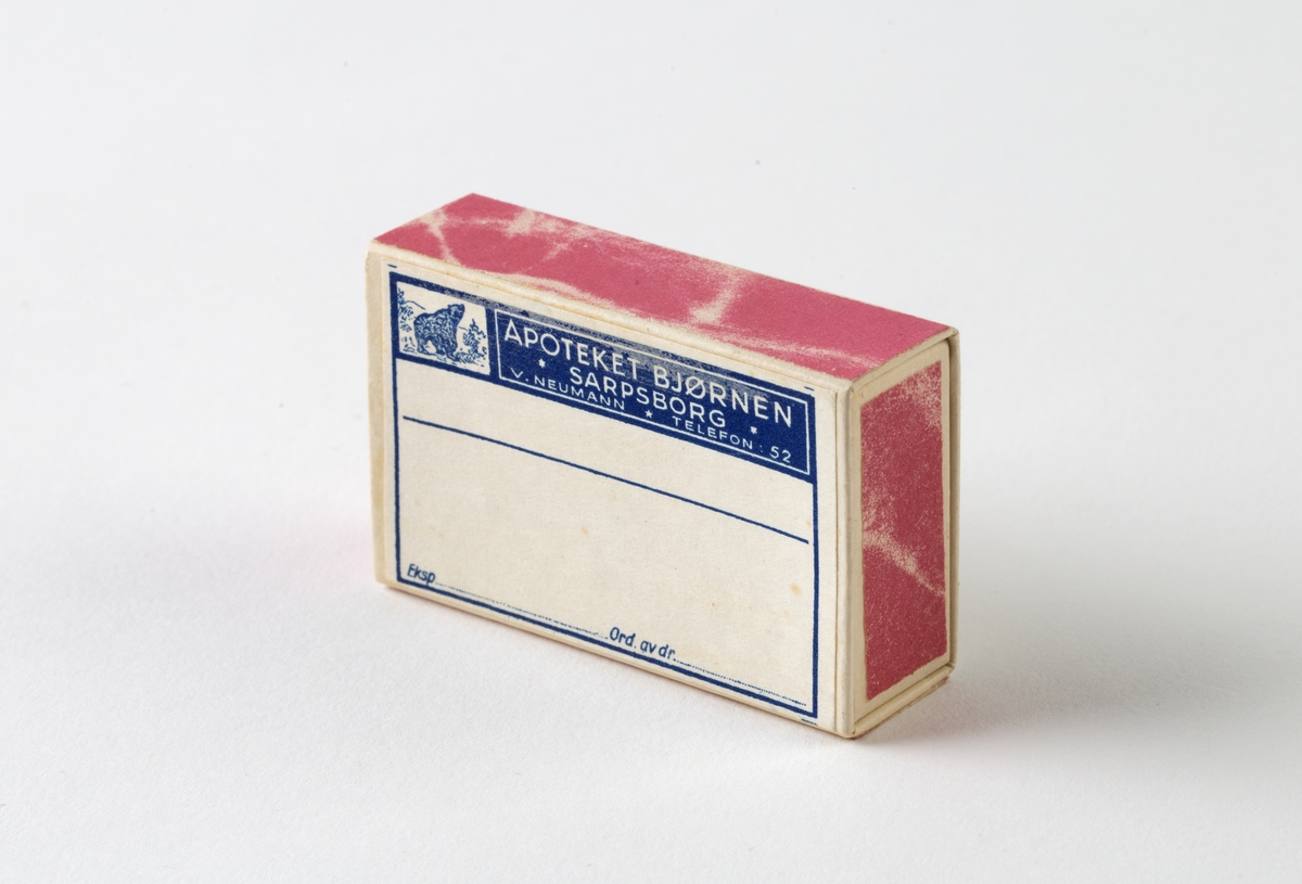 Eske av kartong med lokk. Inndelt i 24 rom med 23 måleglass. Hvert måleglass med innstøpt gradering på ene siden opp til 20 ml, på annen side 1 TE EL / 1/2 E SSL / 1 ES SL.
Esken er holdt sammen med hyssing. På lokket notert med blyant: 5704