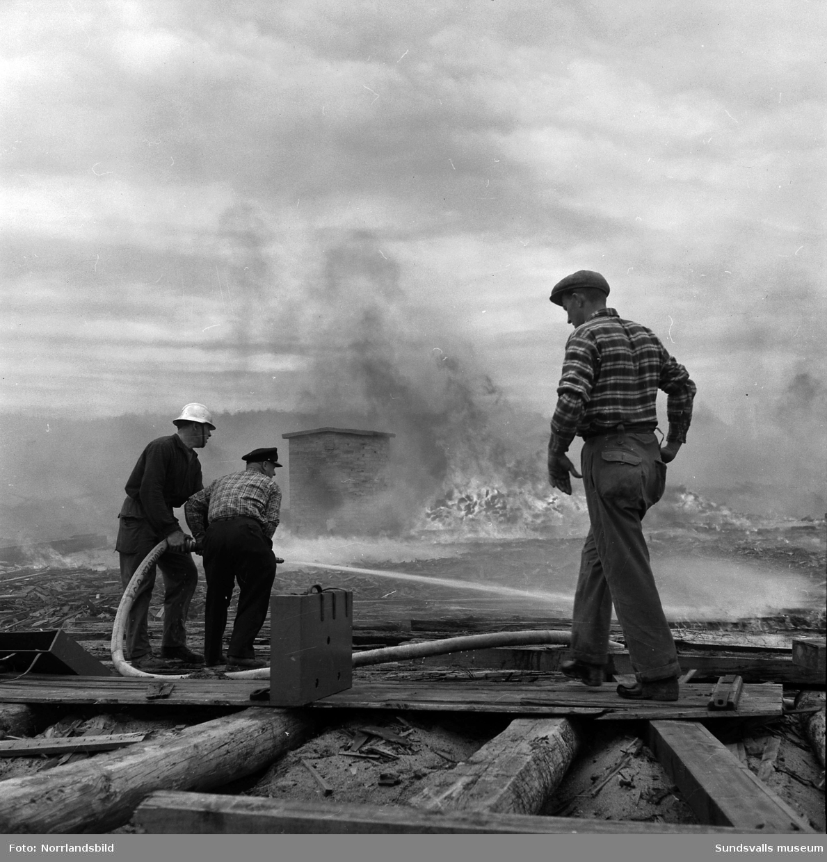 Brand på brädgården vid Sunds nedlagda sågverk. Brandmän från såväl Sundsvalls som Sköns brandkårer kämpade med släckningsarbetet som blev besvärligt på grund av blåsten.