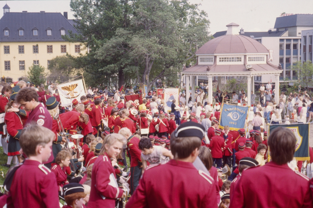 Korpsmusikere med faner rundt paviljongen i Generalhagen.