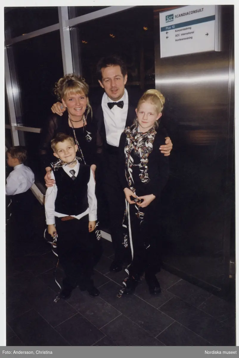 Nyårsfirande i Skandiahuset, Stockholm vid millenieskiftet 1999/2000. Familjen Andersson i hissen upp till takterrassen för att se fyrverkerierna vid tolvslaget. Från vänster Eric, China, Lasse och Amanda Andersson.