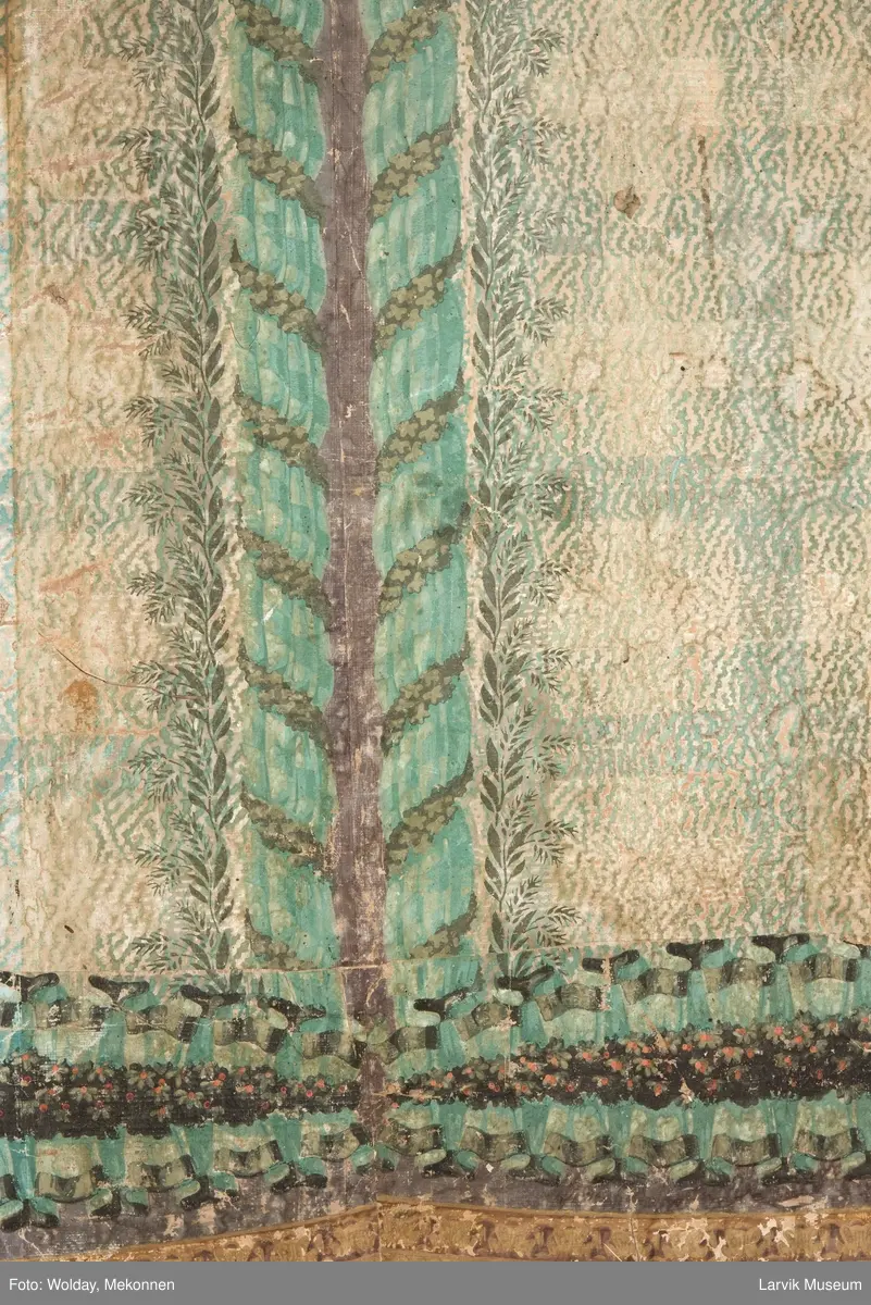 |Tapeten er påmalt tapetborder og brystning. Fra Hovland gård i Larvik.
Den øverste, brede borden: Gerlander/draperi med blomsterranker.
Den nederste, smalere borden: Tekstilbord med blomster. Øver døren til høyre: Stillebenmotiv med blomster og frukt.