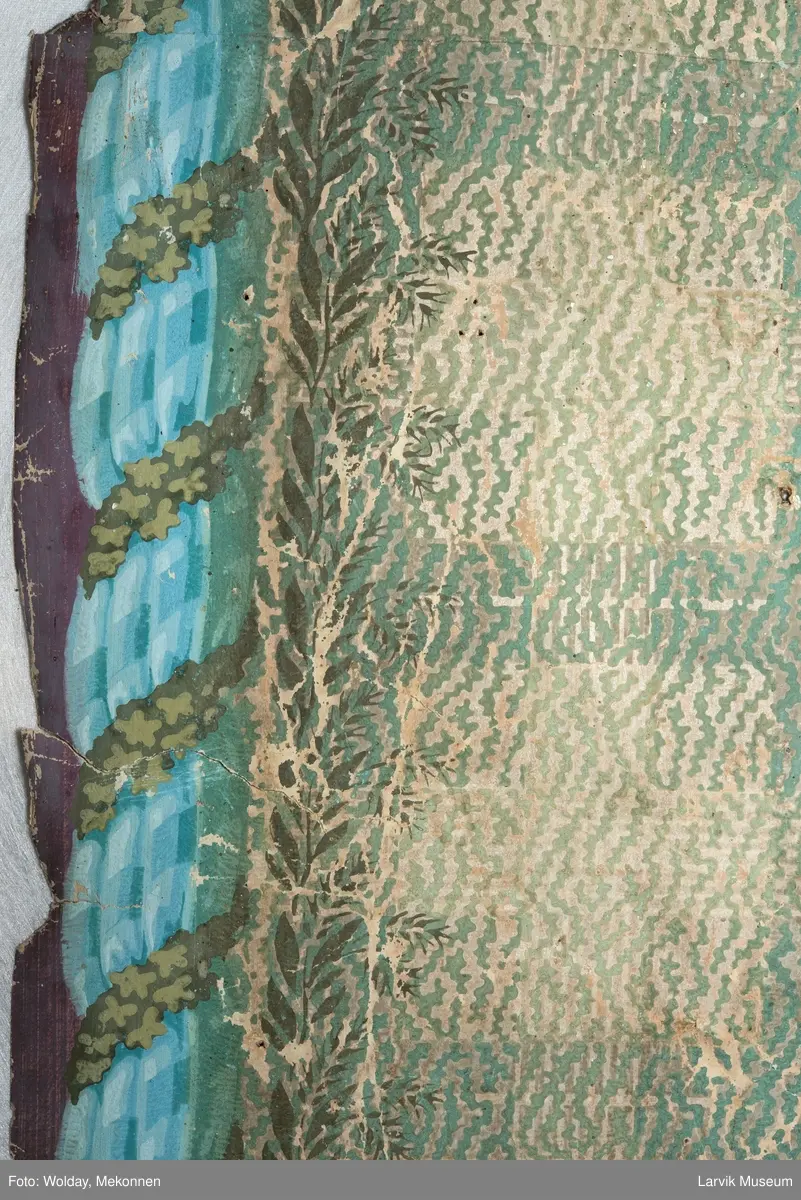 |Tapeten er påmalt tapetborder og brystning. Fra Hovland gård i Larvik.
Den øverste, brede borden: Gerlander/draperi med blomsterranker.
Den nederste, smalere borden: Tekstilbord med blomster. Øver døren til høyre: Stillebenmotiv med blomster og frukt.