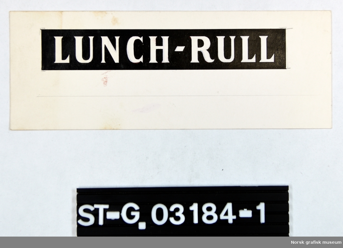 Forarbeid til etikett for Stabburet Lunch-rull.  Original sort-hvitt tegning av teksten: LUNCH-RULL