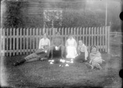 3 kvinner, 3 menn i uniform foran hus med gjerde