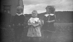 Tre pyntet små barn ute.