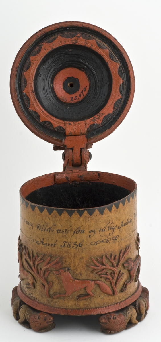 Dekorert med fortløpende billedfrise med dyr og trær på nederste del av korpus. Kannen har løveføtter og løvegjekk og bakkantine som håndtak. 