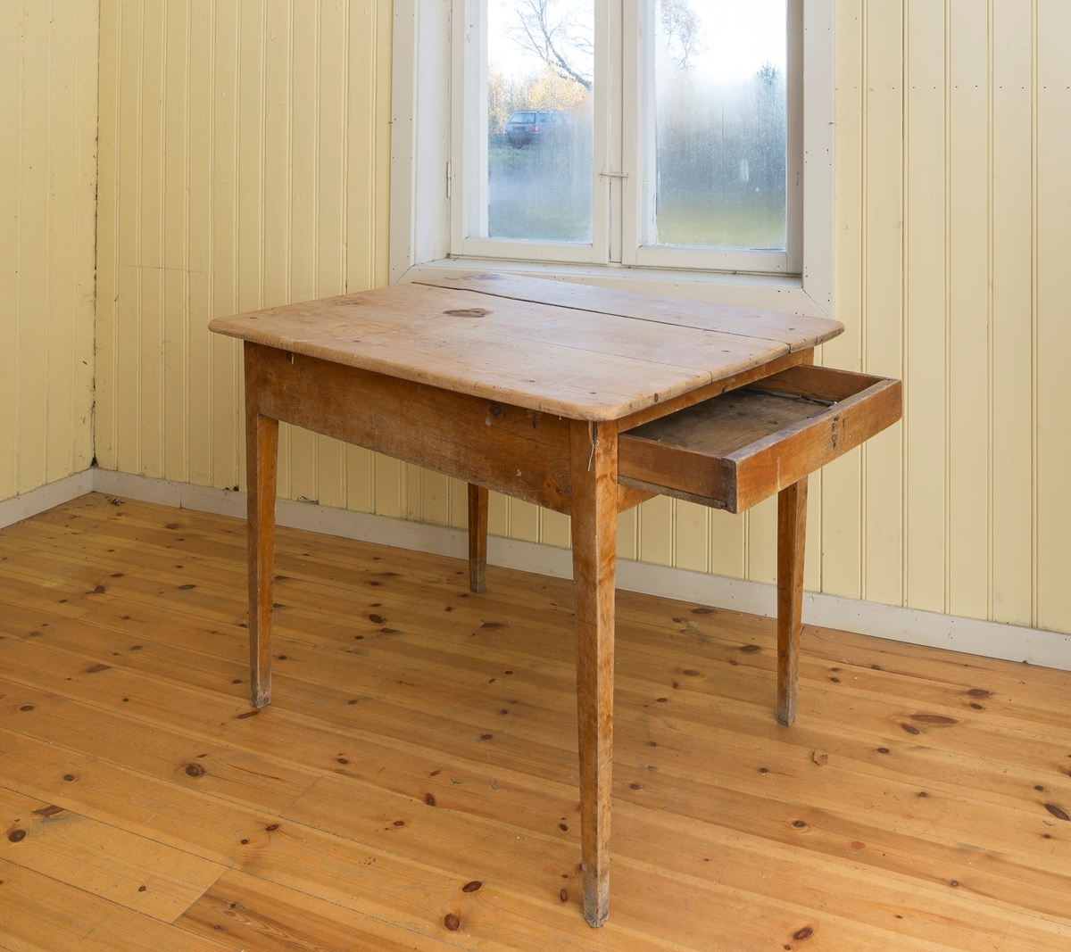 Spisebord med skuff. Satt sammen av 4 bordplater. Manglet lås og nøkkel. Lakkerte ben.