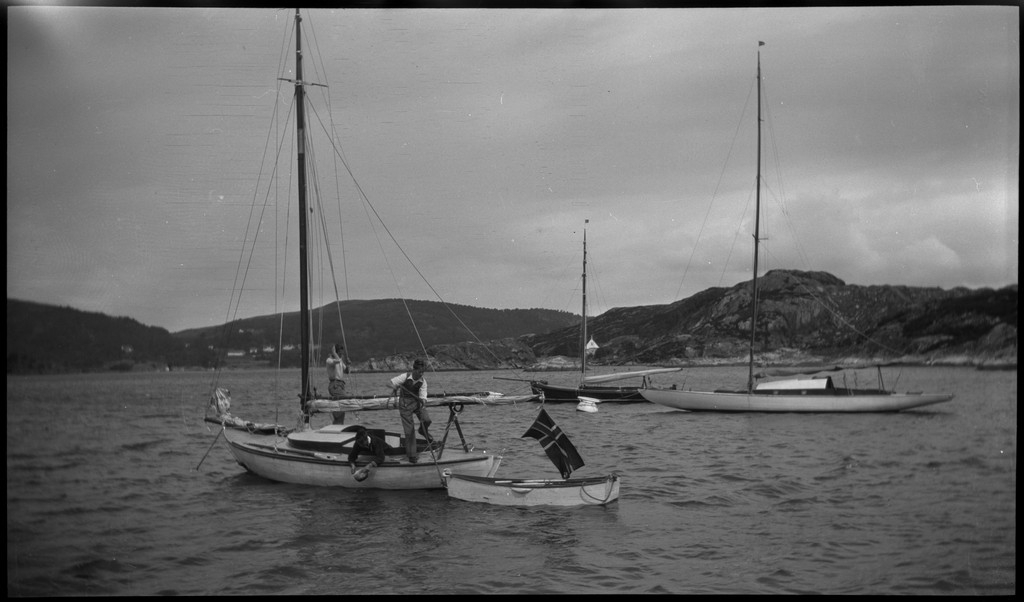 Per Årseth, Karl Karlsen og Børge Gabrielsen ved ei naturhavn med seilbåten "Vilja". Det ligger flere andre seilbåter på svai.