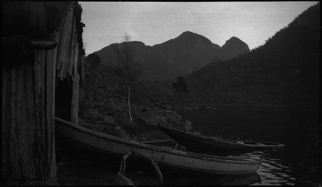 Noen gutter står ved en demning i nærheten av Jørpeland og Dalen og bilder fra et sted i nærheten av Småsilkomplekset, muligens fra Dalen. Småsilhornet og Heiahornet ruver opp i bakgrunnen.