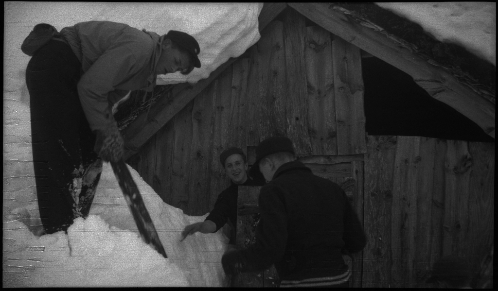 En guttegjeng på skitur i fjellene ovenfor Saudasjøen. Det er bilder av gjengen som går oppover bakkene, og fra en pause ved en gammel hytte.