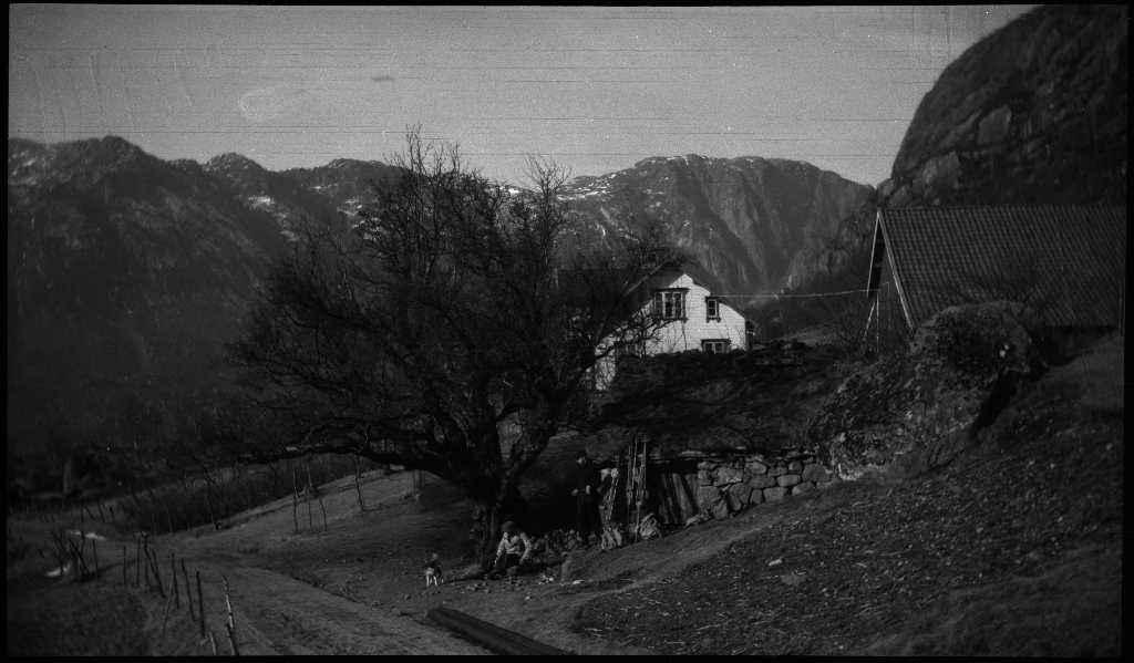Finn Johannessen, Lindtner og Arne Johannessen ved en gård, og ved noen berg før eller etter en skitur ved Oaland i Forsand kommune. Det er også bilder av Lindtner og Arne Johannessen som bærer skiene på ryggen nedover en bakke.