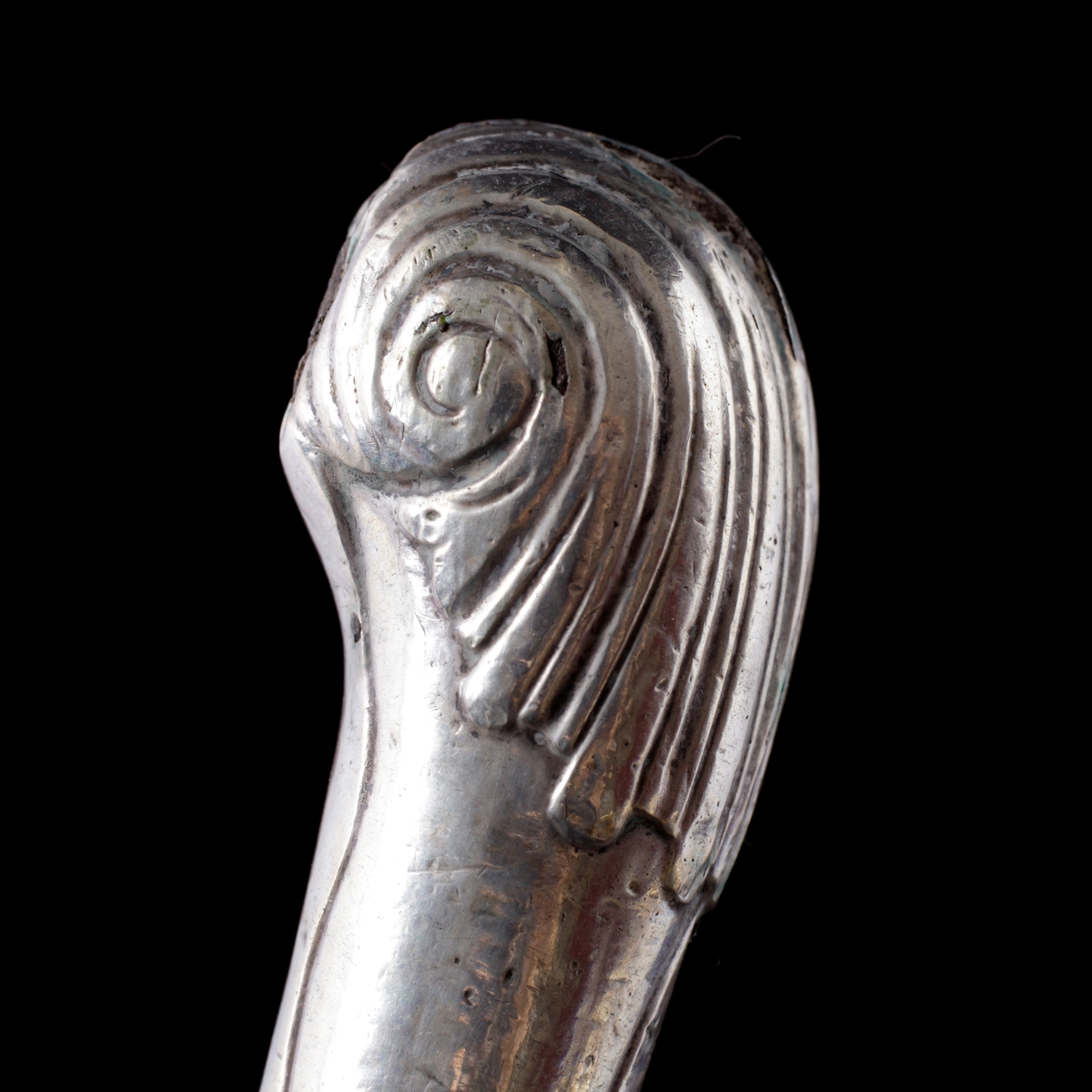 Bordsgaffel, tvåtenad i silver. 
Pistolmodell. Stämpel på skaftets nedre del: "I.W". (Kan möjligen vara: Jeremias Wallbom (1776-1807), Uddevalla).