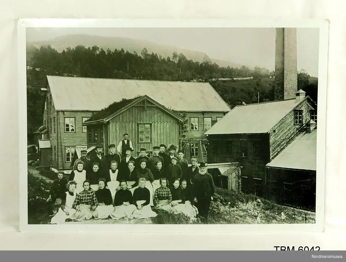 Fotografi av arbeiderne på fabrikken i 1901. Skilt med namnet på personene på bildet.