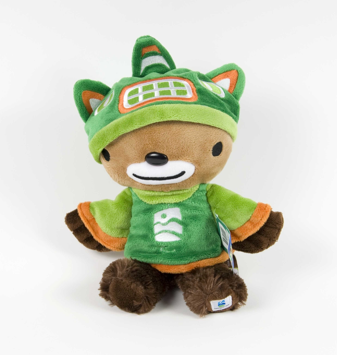 Flerfarget figur av Sumi; maskotene for Paralympics i Vancouver i 2010. Figuren har grønn genser/jakke og grønn lue. På jakken/genseren er det emblem for de olympiske vinterleker i Vancouver.