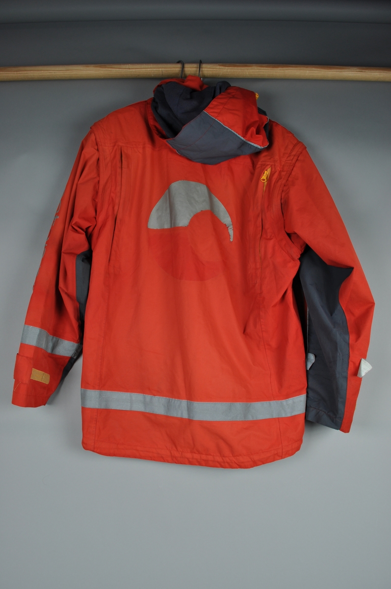 Vinterjakke uten fleecefor. Med hette, avtagbare ermer. 4 lommer foran med borrelås. 2 sidelommer med glidelås. Refleks på ermene og i nedkant av jakka. fastsydde skulderklaffer med uniformsknapp av metall. Lufteklaff i rygg.  Størrelse S