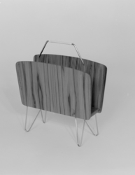 Aviskorg med handtak og føter i metall.