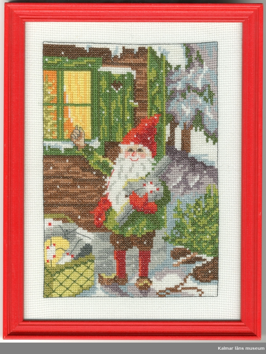 En tomte står utanför ett hus och knackar med ena handen på fönsterrutan. Han bär paket i den andra handen och på marken står en korg med julklappar.
