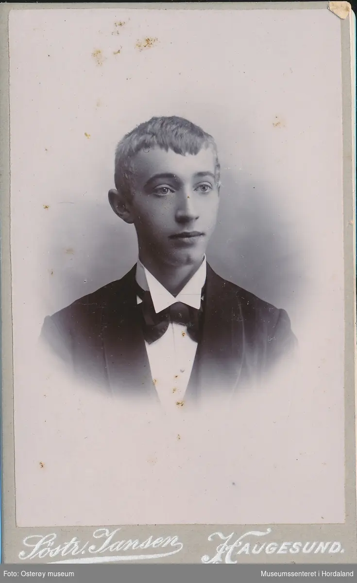 portrettfotografi av ung mann/gut med svart smokingjakke, kvit skjorte med stiv snipp og svart sløyfe